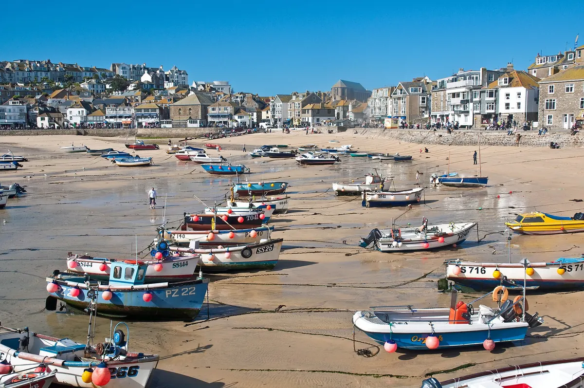 St Ives harbour at low tide, with boats resting on the sand below the town